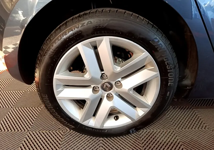 Vue rapprochée de la roue arrière droite d'une Renault Clio gris foncé avec pneu Bridgestone visible.