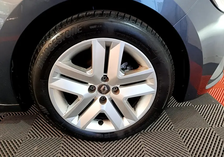 Vue rapprochée de la roue avant droite d'une Renault Clio Business TCe 90 gris foncé avec passage de roue arrondi.