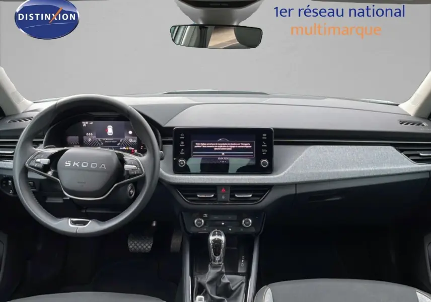 Vue intérieure frontale du tableau de bord du Skoda Kamiq 2025 avec volant multifonction et écran tactile central.