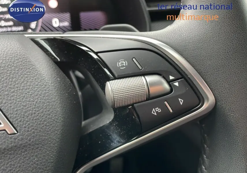 Gros plan sur les commandes multifonctions au volant noir du Skoda Kamiq blanc Glacier 2025, version Selection.