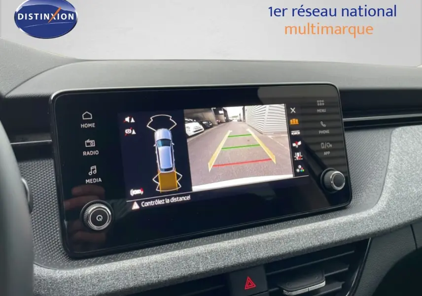Écran central du Skoda Kamiq blanc glacier 2025 affichant la caméra de recul avec guidage de trajectoire.