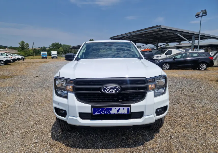 Vue frontale d'un Ford Ranger Super Cabine blanc avec calandre noire et plaque d'immatriculation Zéro KM.