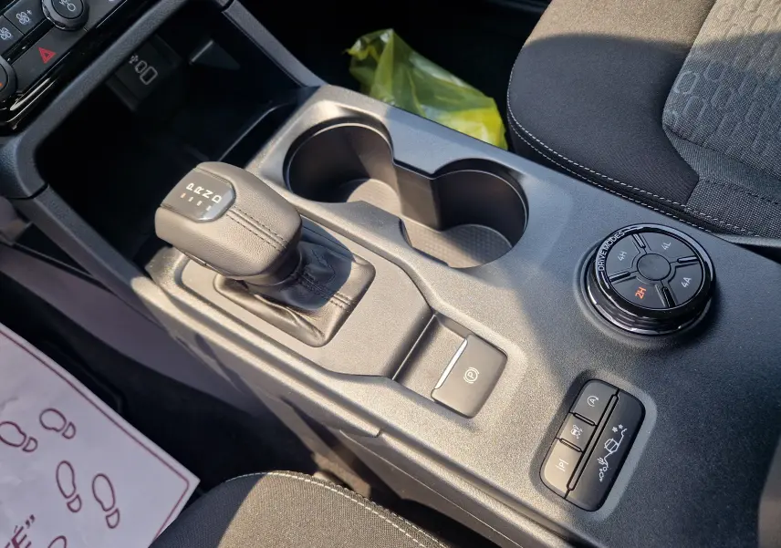 Gros plan sur la console centrale du Ford Ranger Super Cabine blanc, montrant levier de vitesses et sélecteur de modes 4x4.
