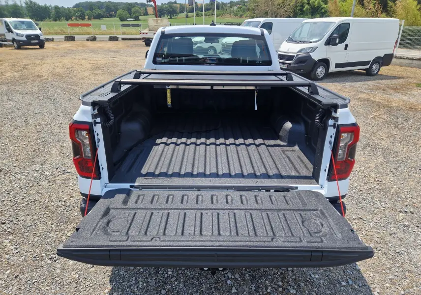 Vue arrière du Ford Ranger Super Cabine blanc avec plateau ouvert et rideau rigide coulissant visible.