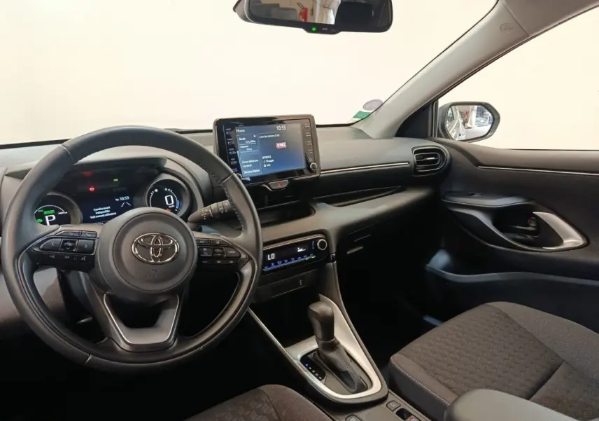 Vue intérieure côté conducteur de la Toyota Yaris Hybride 116h Design 2023, tableau de bord et écran tactile central visibles.