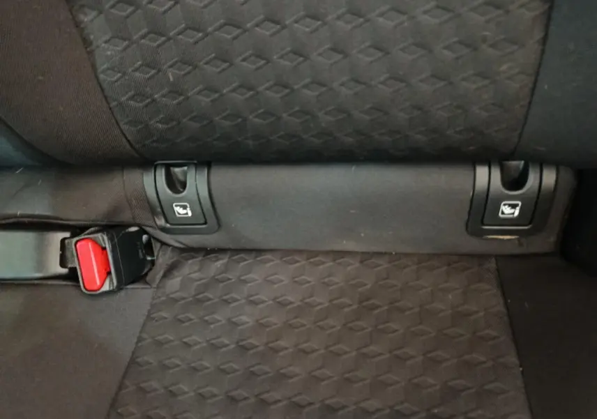 Détail de la banquette arrière noire de la Toyota Yaris hybride 2023, montrant les attaches Isofix et la boucle de ceinture.