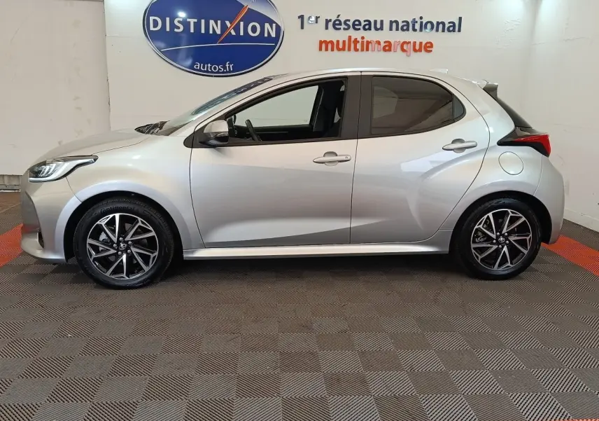 Profil côté gauche de la Toyota Yaris Hybride 116h Design gris clair 2023, avec jantes alliage et feux arrière distinctifs.