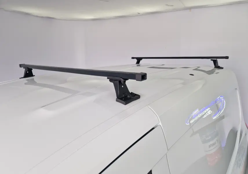 Vue rapprochée du toit blanc du Renault Kangoo 2023 avec barres de toit noires installées.