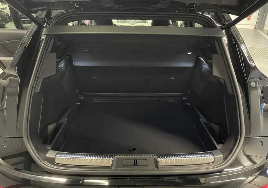 Coffre ouvert du DS7 Crossback noir métallisé, vue arrière montrant l’espace de chargement et le seuil chromé.
