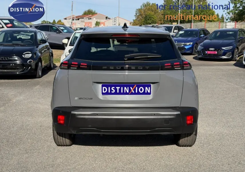 Vue arrière d’un Peugeot e-2008 gris Artense avec feux LED caractéristiques et lunette arrière teintée.