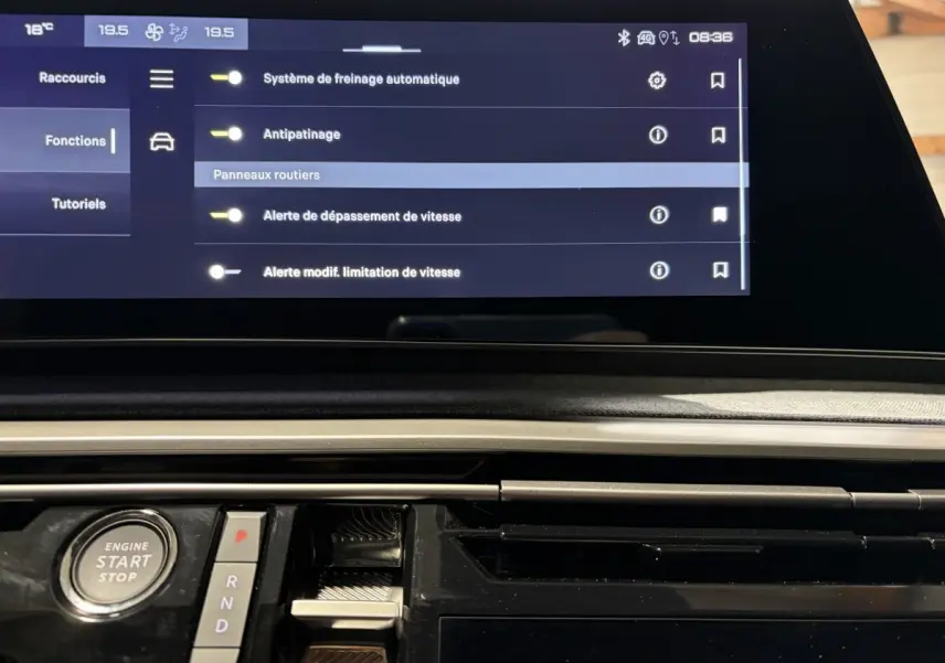 Vue rapprochée de la console centrale du Peugeot 3008 blanc, avec écran tactile et bouton démarrage visible.