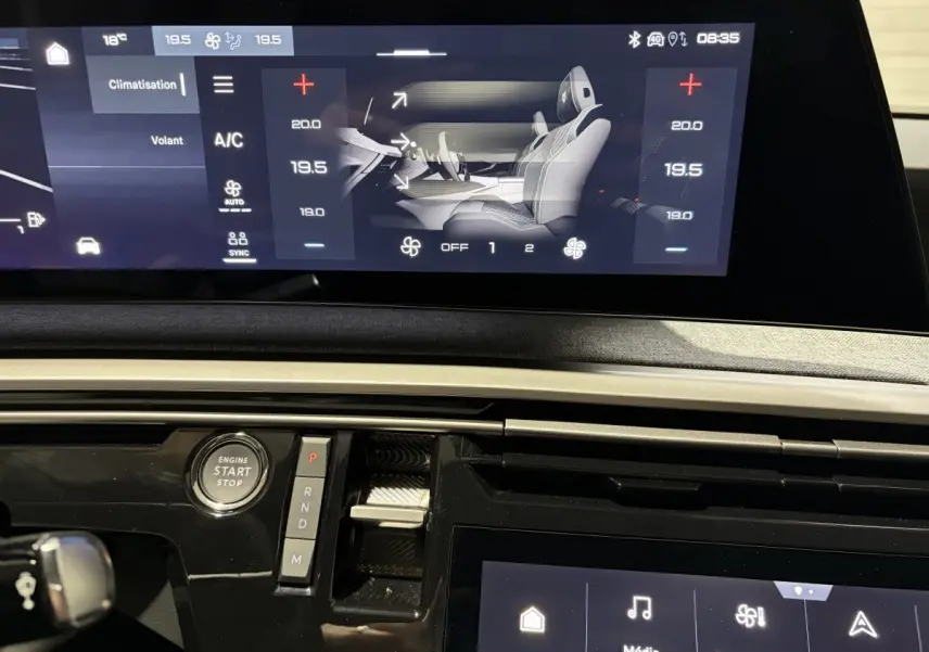 Vue rapprochée du tableau de bord du Peugeot 3008 blanc 2026 avec écran tactile et bouton démarrage visible.