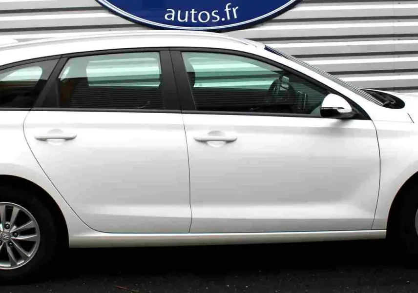 Profil côté droit d'une Hyundai i30 SW blanche polaire 2022 avec jantes alliage et vitres teintées.