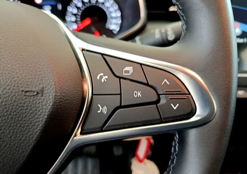 Gros plan sur les commandes multifonctions à droite du volant cuir de la Renault Clio Business TCe 100 blanche de 2020.