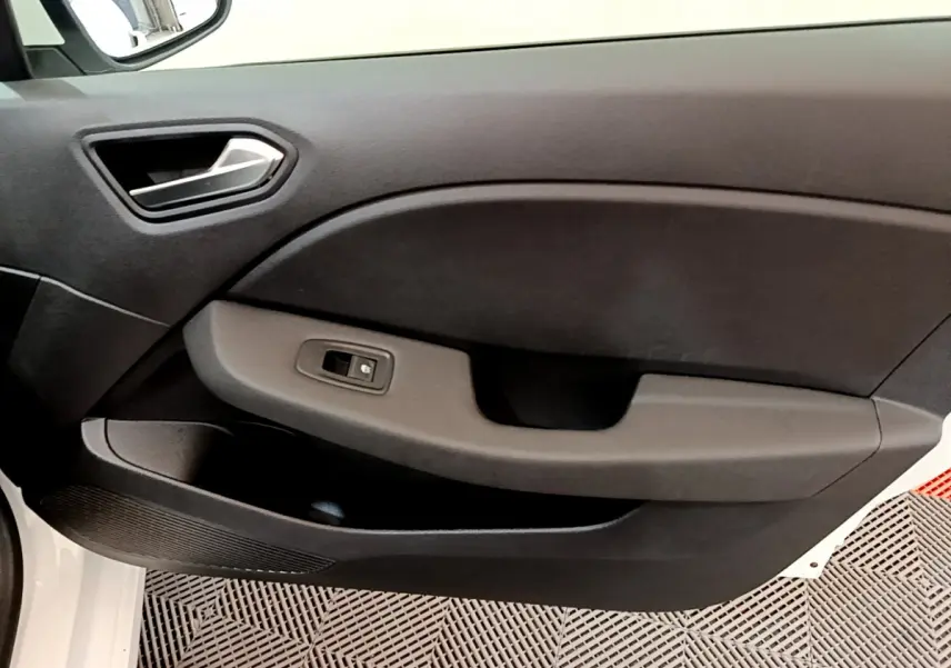 Gros plan sur la porte côté gauche intérieure de la Renault Clio Business blanche, avec commande de vitre électrique.
