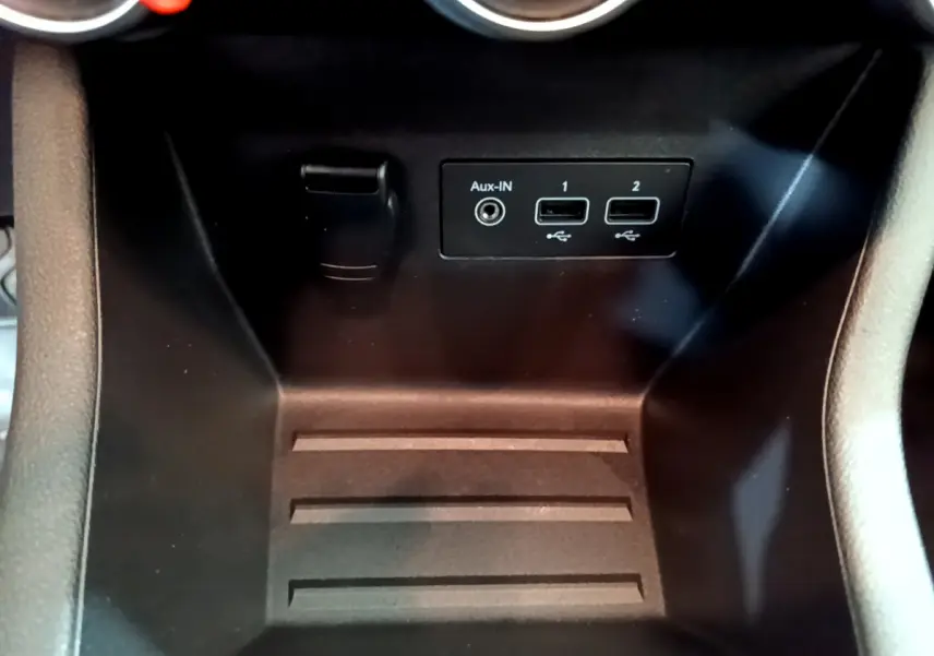 Vue rapprochée du compartiment central noir avec prises USB et entrée Aux-In de la Renault Clio Business blanche 2020.