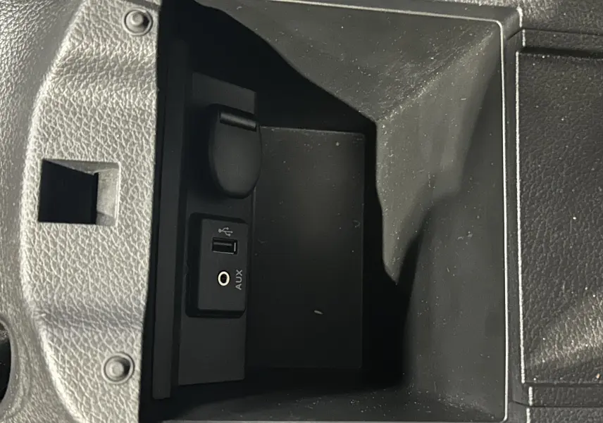 Gros plan sur la prise USB et port AUX dans le rangement central intérieur d'une Nissan Pulsar gris 2018.