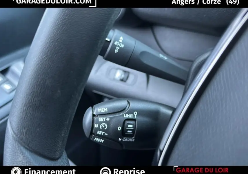 Gros plan sur les commandes au volant du Peugeot Rifter 2024 bleu, mettant en valeur le régulateur de vitesse et les commandes limitateur.