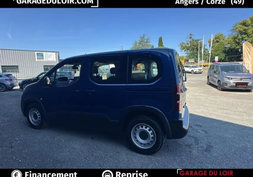 Vue de profil côté gauche d’un Peugeot Rifter bleu 2024 version 1.5 BlueHDi 100 S&S Taille M Allure en extérieur.