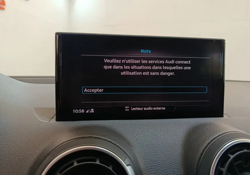 Écran tactile central affichant un message d’avertissement dans l’habitacle d’un Audi Q2 gris foncé.