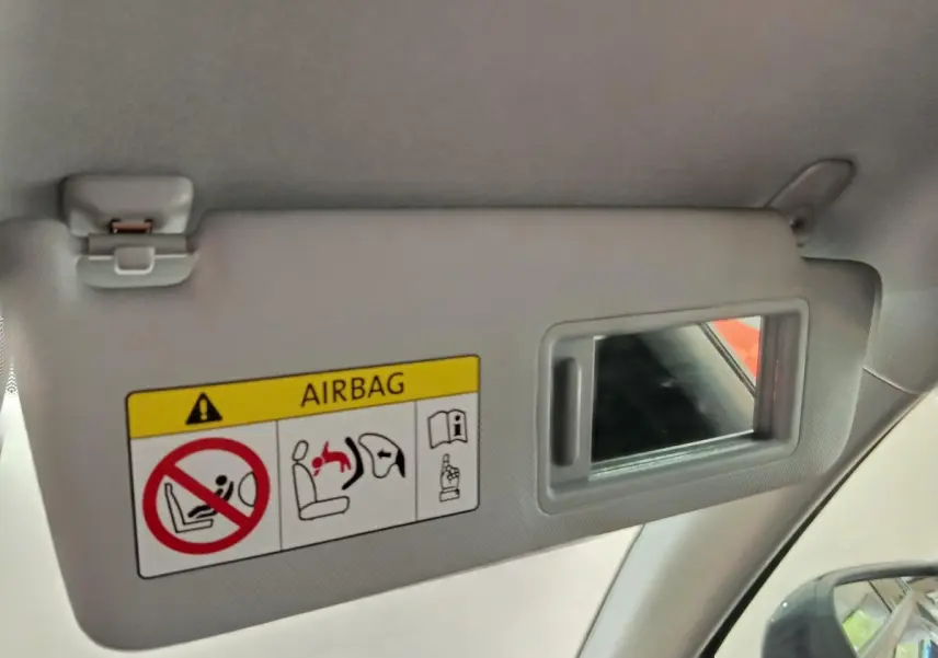 Détail du pare-soleil côté conducteur avec miroir intégré et avertissement airbag dans l’Audi Q2 gris foncé.