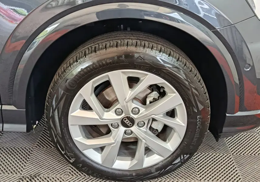 Gros plan sur la roue avant droite d’un Audi Q2 gris foncé, avec jante en alliage et pneu Continental.