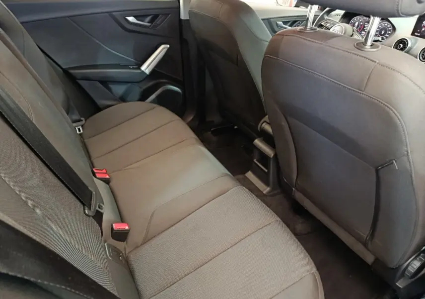 Vue intérieure arrière côté droit de l'Audi Q2 35 TFSI 150 S Tronic Business Line 2022 avec sièges tissu gris foncé.
