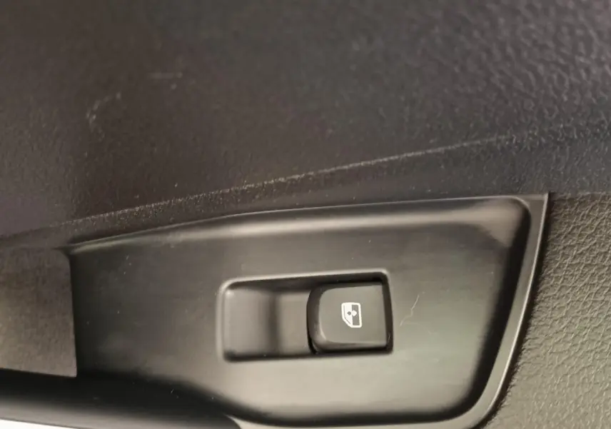 Gros plan sur le bouton de commande de la ventilation additionnelle siège passager dans un Audi Q2 gris foncé 2022.