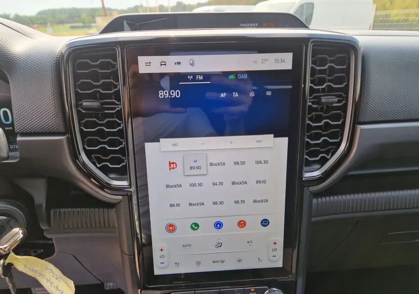Vue rapprochée de l’écran tactile central 12,4 pouces du Ford Ranger Super Cabine blanc, avec commandes climatisation et audio visibles.