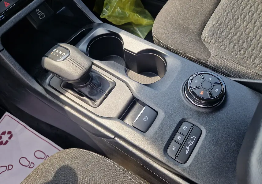 Vue rapprochée de la console centrale du Ford Ranger blanc, avec levier de boîte auto et sélecteur modes de conduite.