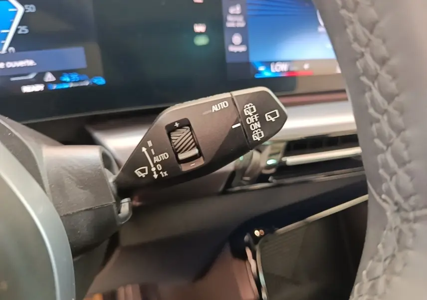 Gros plan sur la commande d’essuie-glace à gauche du volant en cuir gris d’un BMW X1 xDrive25e M Sport 2023.