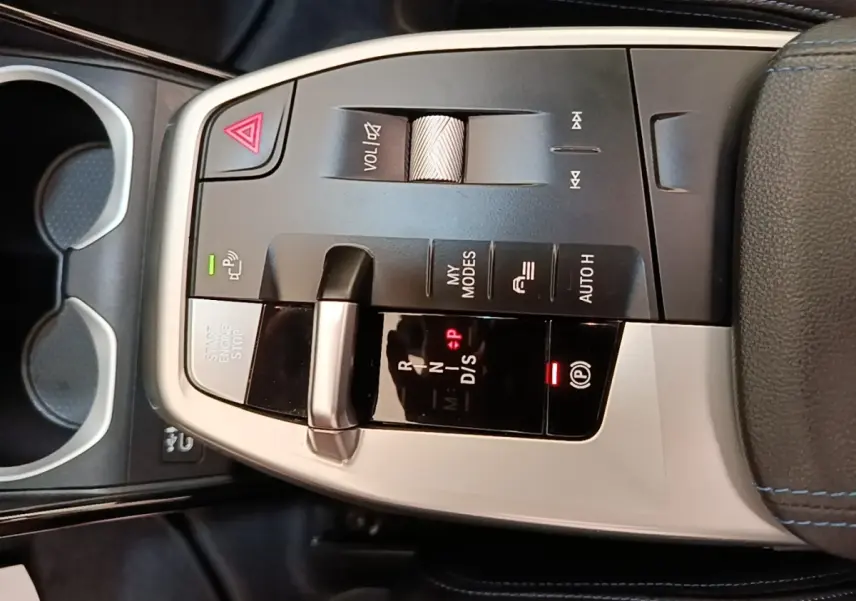 Vue rapprochée de la console centrale du BMW X1 xDrive25e M Sport 2023, avec levier de vitesses et commandes en alu noir et argent.