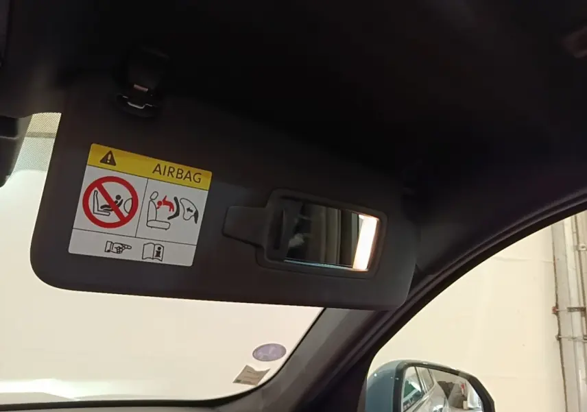 Intérieur BMW X1 xDrive25e M Sport 2023, vue côté droit sur pare-soleil gris avec miroir et rétroviseur extérieur gris foncé.