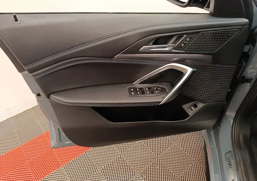 Vue rapprochée de la porte avant gauche gris foncé du BMW X1 xDrive25e M Sport avec garniture noire et insert alu.