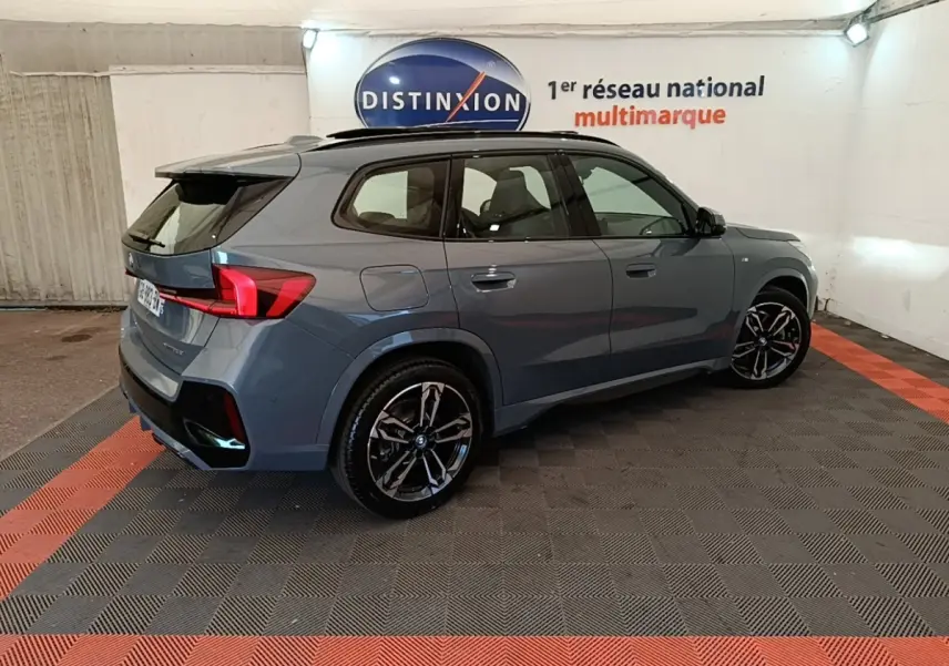 BMW X1 xDrive25e M Sport gris foncé vue 3/4 arrière droit, avec jantes noires et toit ouvrant panoramique.