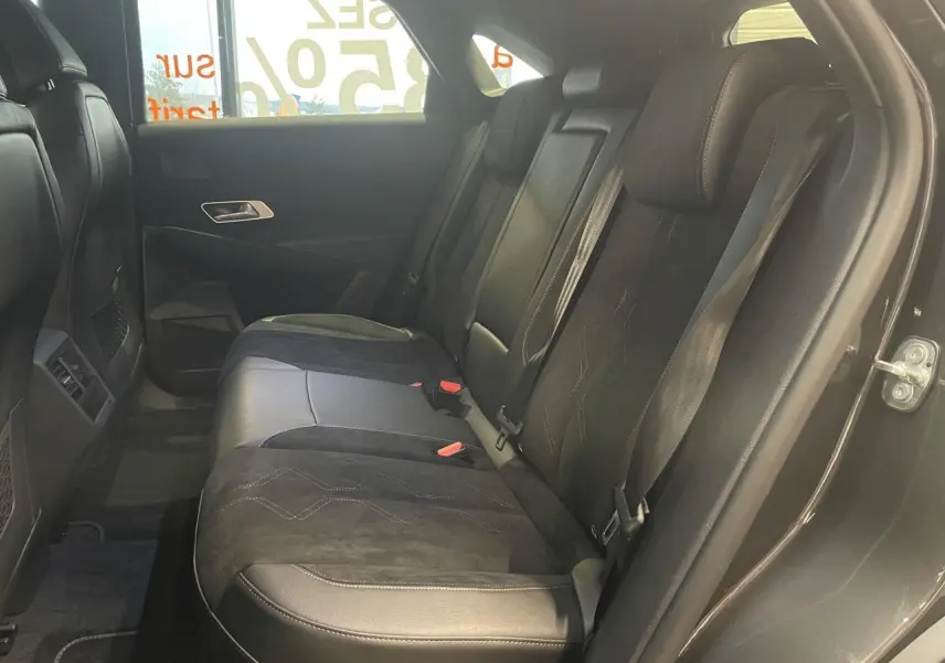 Vue côté droit de la banquette arrière en cuir et Alcantara noir du DS7 Crossback gris titanium, avec ceintures de sécurité visibles.