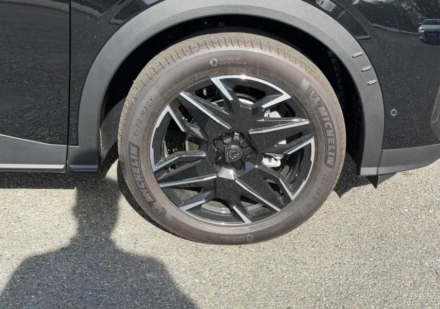 Gros plan sur la roue avant gauche noire avec jante alu au design moderne du Peugeot 3008 noir Perla Nera.