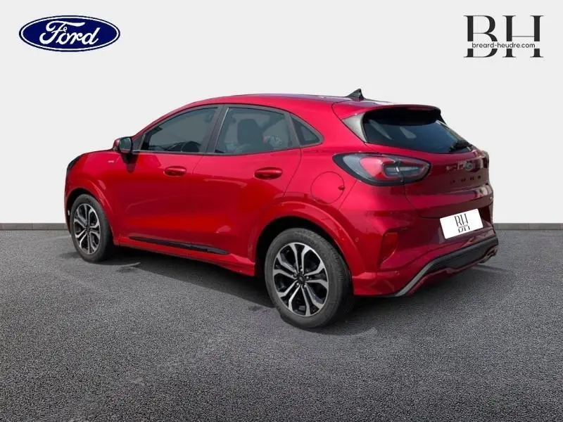 Ford Puma 2022 rouge métallisé vu en 3/4 arrière droit avec jantes alu et feux arrière LED distinctifs.