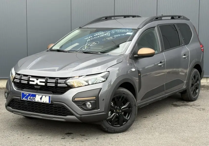 Vue 3/4 avant droit du Dacia Jogger Gris Schiste avec jantes noires et rétroviseurs couleur cuivre.