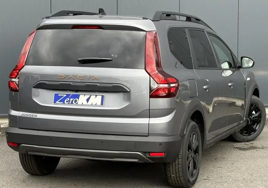 Vue 3/4 arrière droite du Dacia Jogger gris schiste avec vitres arrière surteintées et jantes noires.