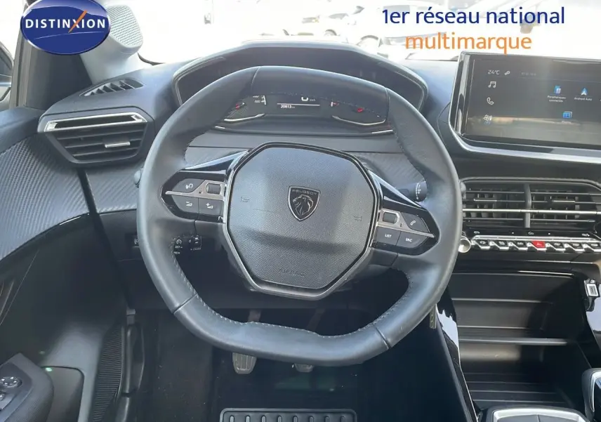 Vue intérieure centrée sur le volant Peugeot 208 2024, avec tableau de bord numérique et écran tactile moderne.