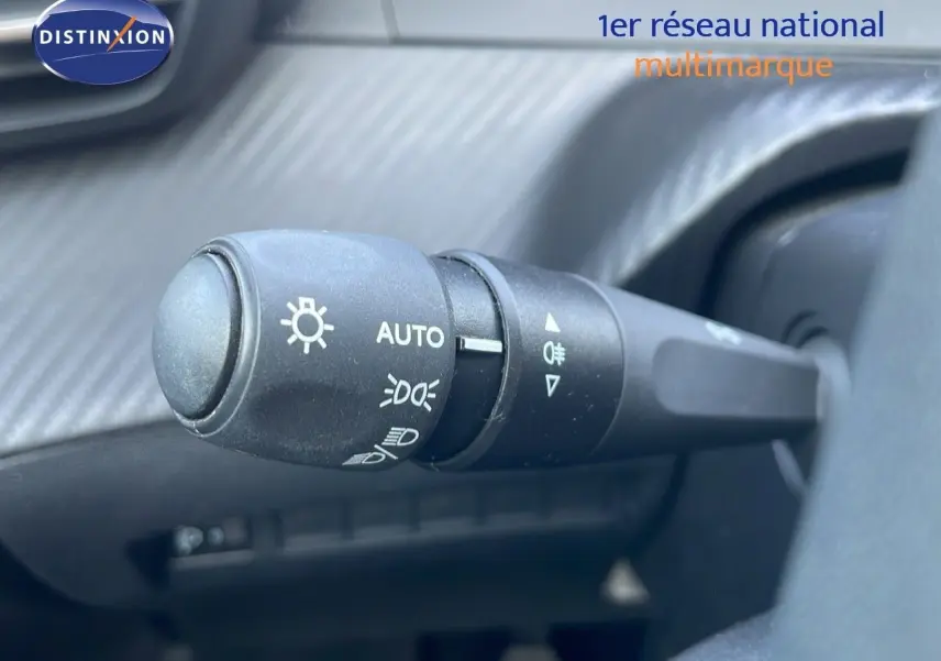 Gros plan sur la commande des phares du Peugeot 208 2024, intérieur noir avec réglage automatique des feux.