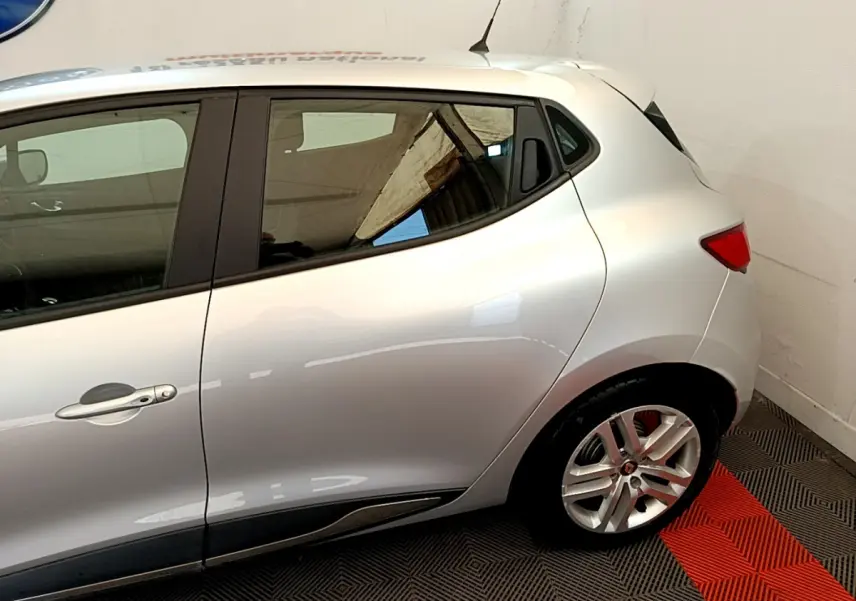 Profil côté droit d'une Renault Clio Business TCe 90 gris clair, mettant en valeur la ligne fluide et la jante alliage arrière.