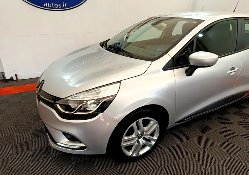 Renault Clio Business TCe 90 gris clair vue 3/4 avant droit, avec phares LED et jantes alliage visibles.