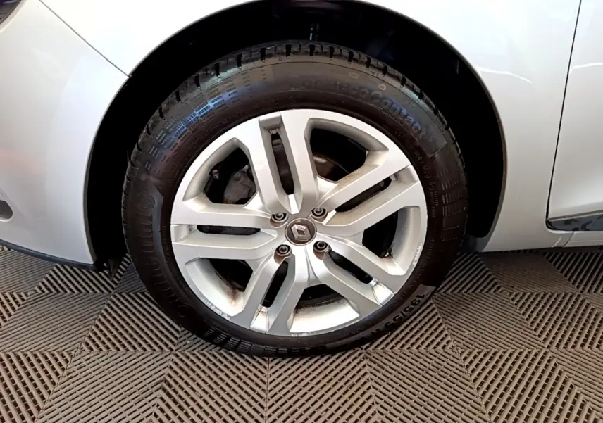 Gros plan sur la roue avant droite d'une Renault Clio Business TCe 90 gris clair avec jante alliage cinq branches.