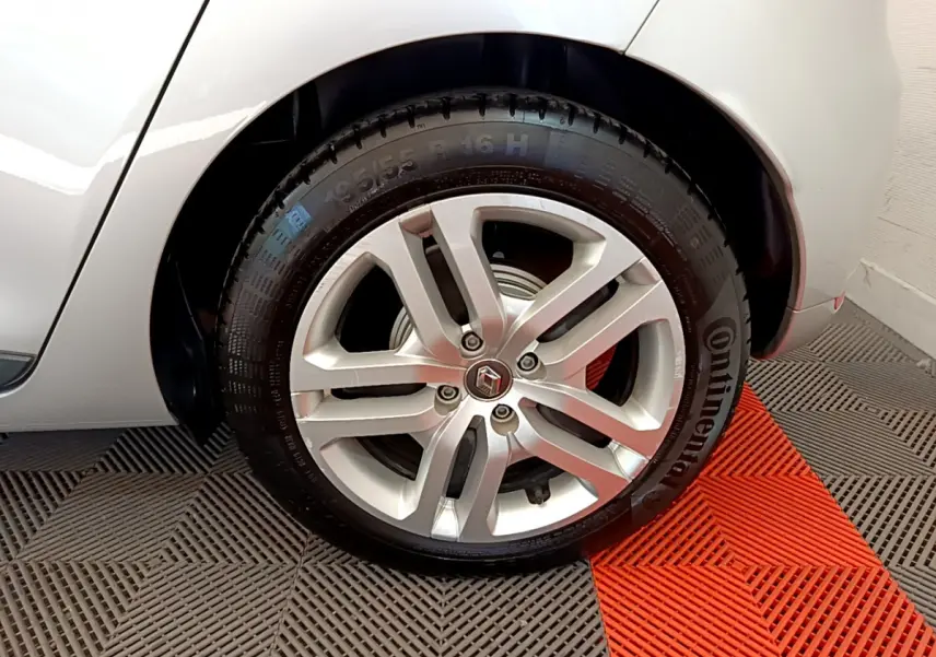 Gros plan sur la roue arrière droite d'une Renault Clio Business TCe 90 gris clair avec jante alliage et logo Renault central.