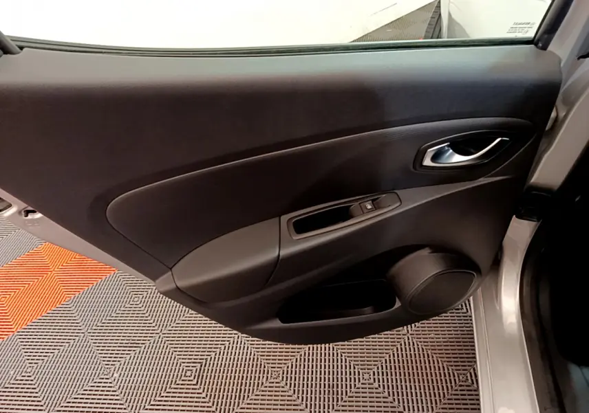 Porte arrière droite ouverte d'une Renault Clio Business TCe 90 gris clair, montrant le panneau intérieur noir avec poignée et commande de vitre.