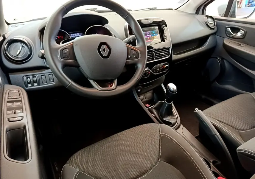 Intérieur de Renault Clio Business TCe 90 2019 vu côté conducteur, volant cuir, écran tactile et boîte manuelle visibles.