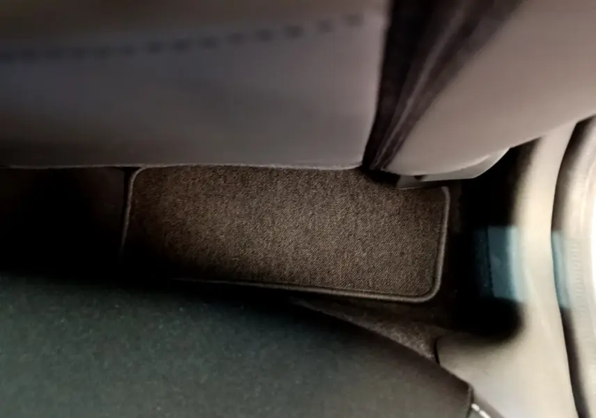 Détail du tapis de sol noir côté passager arrière d'une Renault Clio Business TCe 90 gris clair de 2019.