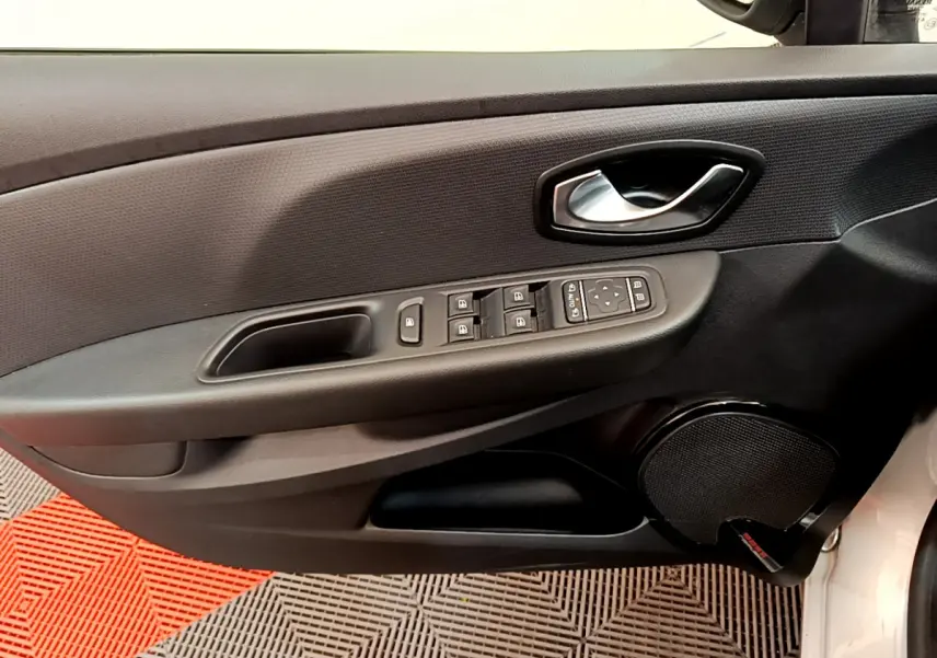 Vue intérieure du panneau de porte conducteur gris foncé de la Renault Clio Business TCe 90 avec commandes électriques et haut-parleur intégré.